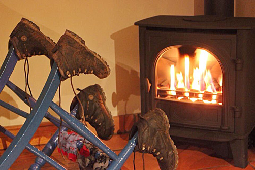 Boots drying by the stove in the River Cabin